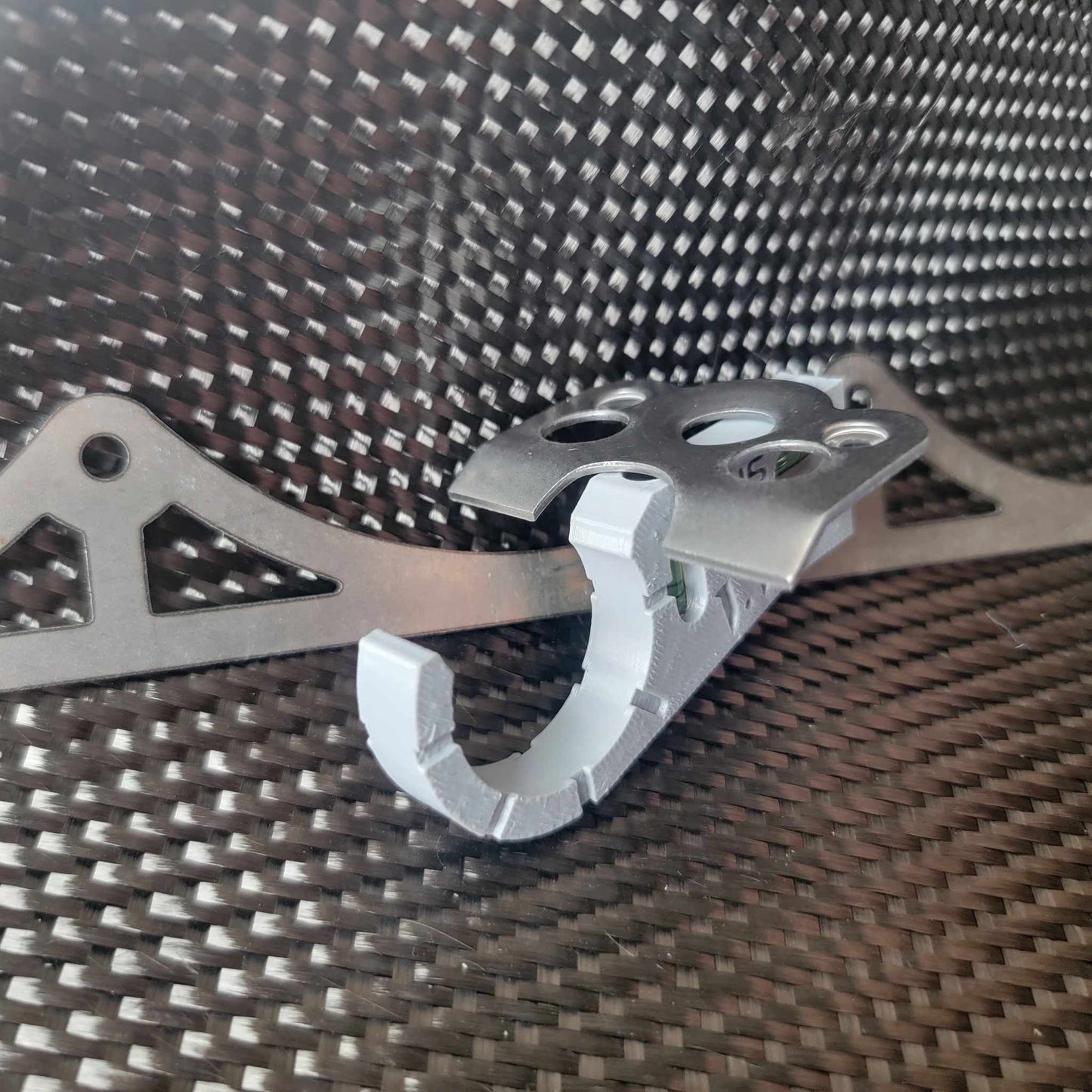 Dzus tab chassis speed jig clipped onto round tubing, aligning a quarter turn fastener plate flush for welding