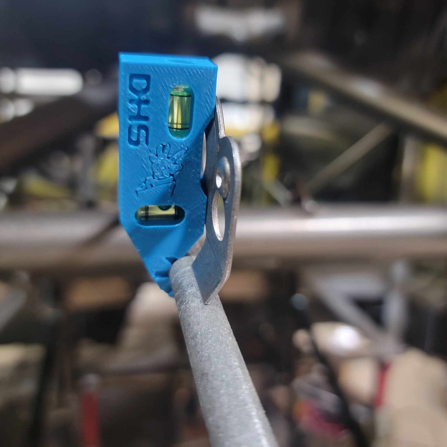 Dzus tab chassis speed jig clipped onto round tubing, aligning a quarter turn fastener plate flush for welding