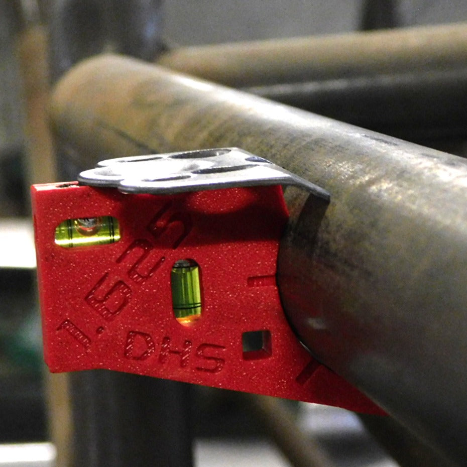 Close-up of Dead Hand Solutions Chassis Speed Jig positioning a Dzus quarter-turn fastener tab flush against roll cage tubing before welding
